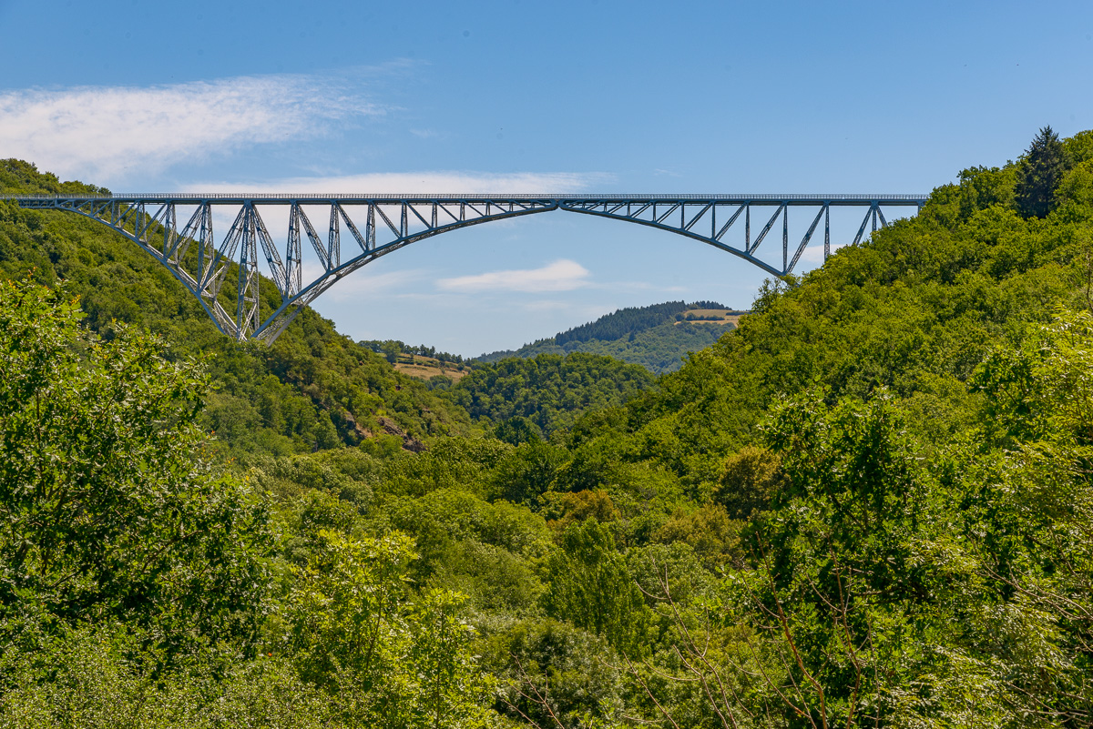 L’architecture aérienne se détache de la vallée boisée en laissant apparaître le ciel au milieu de son armature. Un objet insolite, qui surprend par la finesse de son dessin, aéré et aérien, jailli d’une forêt dense qui semble inhabitée. Une perception qui tranche avec celle des plateaux agricoles et ouverts.